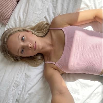 AI image to nsfw character creator: Ai Girlfriend Blonde Pink Tank Bed Soft Light